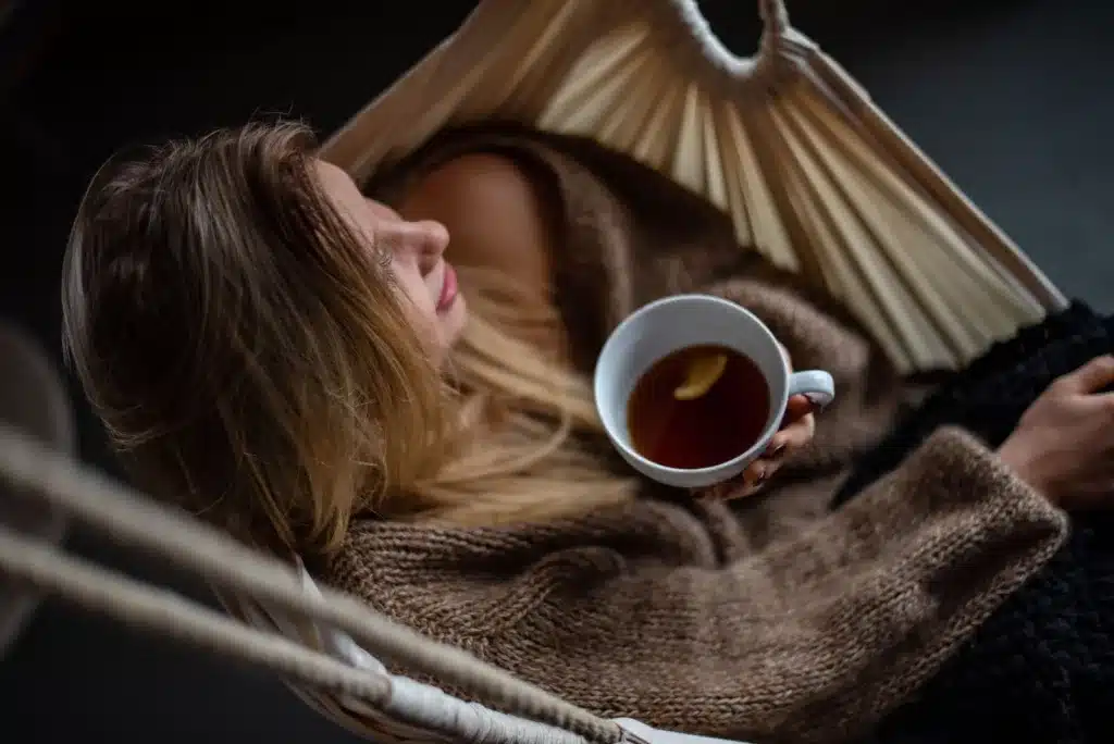 woman on hammock holding cup of coffee. These mindfulness tricks help to reduce stress and cause stress relief.