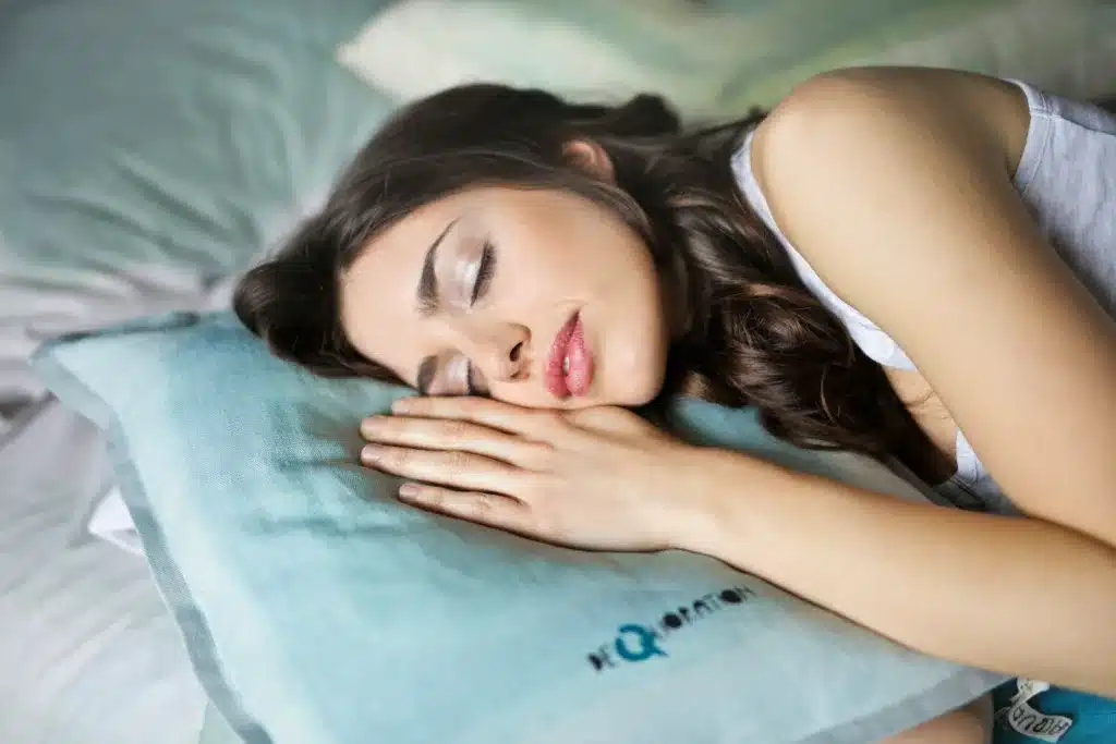 woman sleeping on blue throw pillow. sleep hygiene, adult wellbeing, sleep quality, mental well-being 