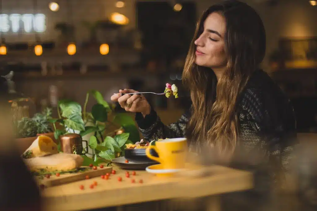 woman holding fork in front table. mental well-being, smart nutrition choices. Eating green, without feeling hungry